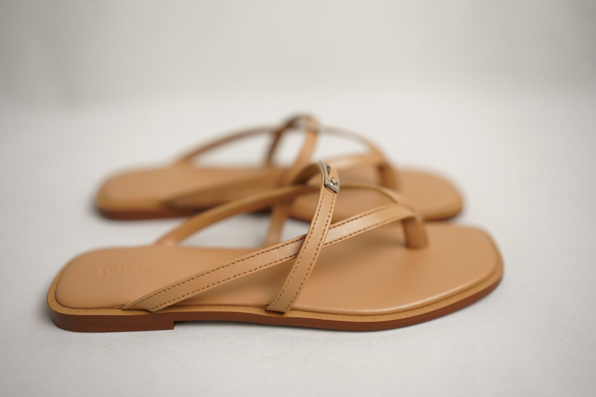 Close-up of gold buckle detail on Nova beige flat sandals